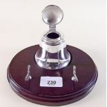 A silver plated inkwell and pen stand on mahogany base