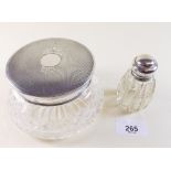 A cut glass powder bowl with silver lid and cut glass perfume bottle with silver lid