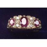 A 9 carat gold ring set three rubies and four chip diamonds - size 0 1/2