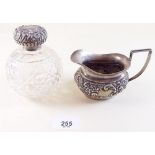 A silver milk jug with embossed decoration by John Henry Wynn, Birmingham 1909 - approx 95g and a