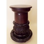 A carved mahogany cylindrical pedestal with leaf decoration
