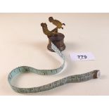 A Victorian gilt metal novelty tape measure with children on a see-saw finial