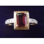 A 10 carat gold emerald cut garnet ring - size N