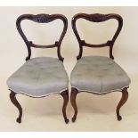 A pair of Victorian rosewood balloon back dining chairs on cabriole supports