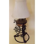 A copper oil lamp on wrought iron stand