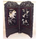 A large Japanese two fold lacquer screen with elaborately carved dragon surmount and surrounds,