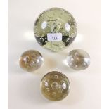 A Victorian large glass dump weight and three similar smaller paperweights