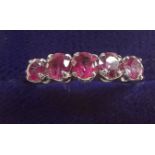 A 14 carat white gold ring set five red stones, size N