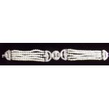 A fine 18ct white gold Art Deco style bracelet, the central geometrical diamond set panel flanked by