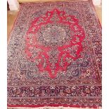 A large Persian style floral rug on red ground with deep blue borders - 238 x 327cm