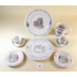 A Wedgwood Peter Rabbit mug and two cups and saucers, a small plate and a large plate