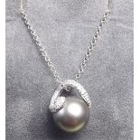 A Beards of Cheltenham grey pearl with diamond scrollwork mount and 18 carat white gold chain -