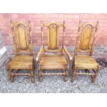 A set of eight Jacobean style panel back oak dining chairs comprising two carvers and six diners