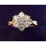 An 18 carat gold diamond cluster ring on crossover shoulders - total one carat