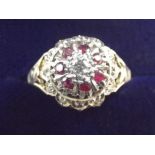 A 9 carat ruby and diamond cluster ring on scroll shoulders, size J