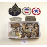 A group of various army buttons and badges