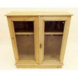 A pine two door glazed bookcase - 105cm high