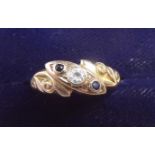 An Edwardian 9 carat gold crossover ring set two sapphires and white stone on scrollwork