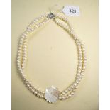 A double strand freshwater pearl necklace with mother of pearl flower panel