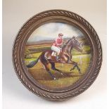 A small circular oil on board of horse and jockey - framed