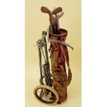 A set of antique golf clubs and caddy