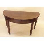 A 19th century mahogany D end console table on square supports and brass feet and castors