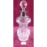 A cut glass decanter with silver collar