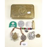 A WWI Princess Mary Christmas tin and contents of cap badges
