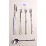 A silver spoon and four mother of pearl handled forks including two fish descalers