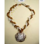 A double strand freshwater pearl necklace with mother of pearl rose