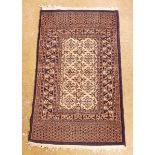 A decorative rug with beige ground and blue border - 73 x 121cm