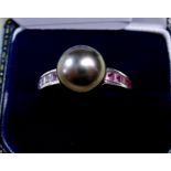 An 18 carat white gold ring set large grey pearl and pink sapphire set shoulders