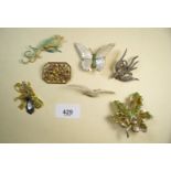 A carved mother of pearl butterfly brooch, two bird brooches, two other vintage brooches and two