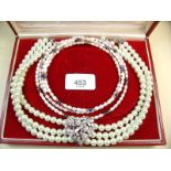 A three strand pearl choker with diamonte heart shaped central panel and three freshwater and sprung