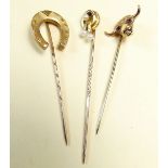 Three stick pins: a 9 carat gold horse shoe one, a 15 carat one set seed pearls, and a bull with
