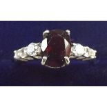 A silver ring set garnets and white stones, size O