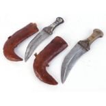 Two Arabian Jambiya knives, each with metal mounted horn handles, leather covered wood scabbards