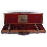 Oak and leather gun case with brass corners and circular escutcheon, red baize lined fitted interior