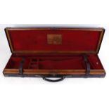 Oak and leather gun case with brass corners, red baize lined interior for up to 31 ins barrels, W.
