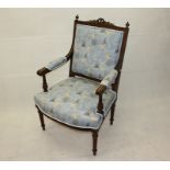 A modern upholstered beech framed armchair, on tapering reeded legs, with laurel wreath and bow to