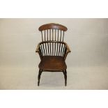 A 19th Century elm spindle back armchair, with shaped seat and cross stretcher