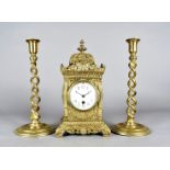 A large brass mantle clock, having white face with black Arabic numerals, the body having raise swag