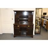 An arts and crafts stained pine cottage dresser, the base having long frieze drawer over central