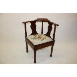 A Georgian mahogany corner chair, the large curved back rail with three tapering back supports,
