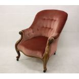 A 19th Century walnut button back armchair, having spoon back, scroll arms and cabriole legs