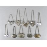 A collection of decanter labels, including silver plate, white metal and ceramic, comprising Gin,