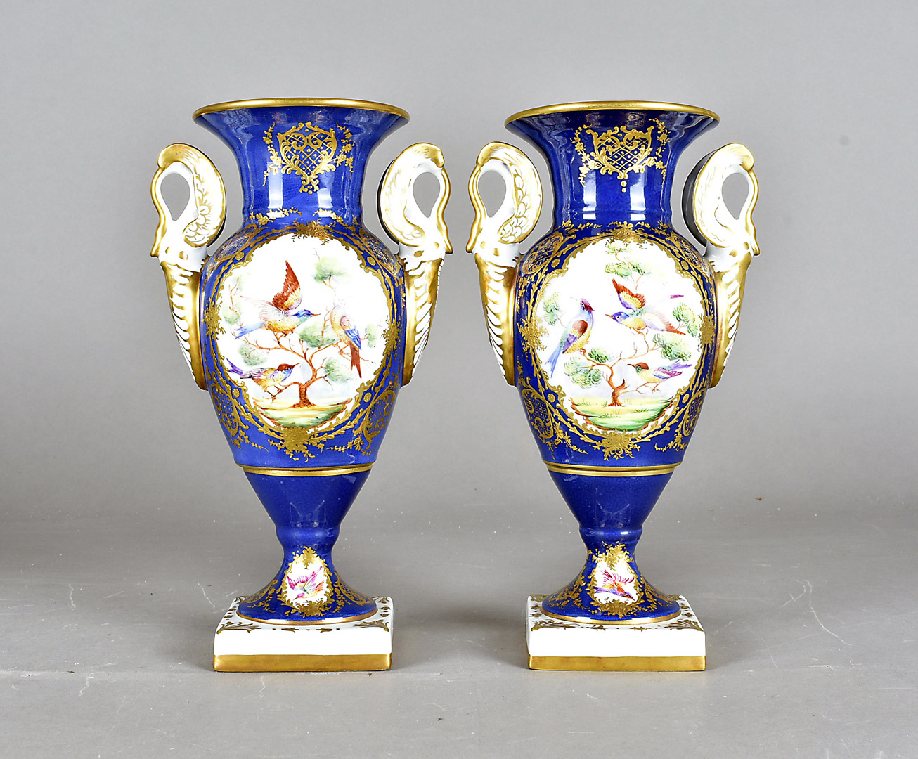 A pair of 1950s French porcelain vases, the twin handled vases having blue ground, with hand painted