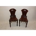 A pair of William IV mahogany hall chairs, with shaped back inset with shields (af) (2)