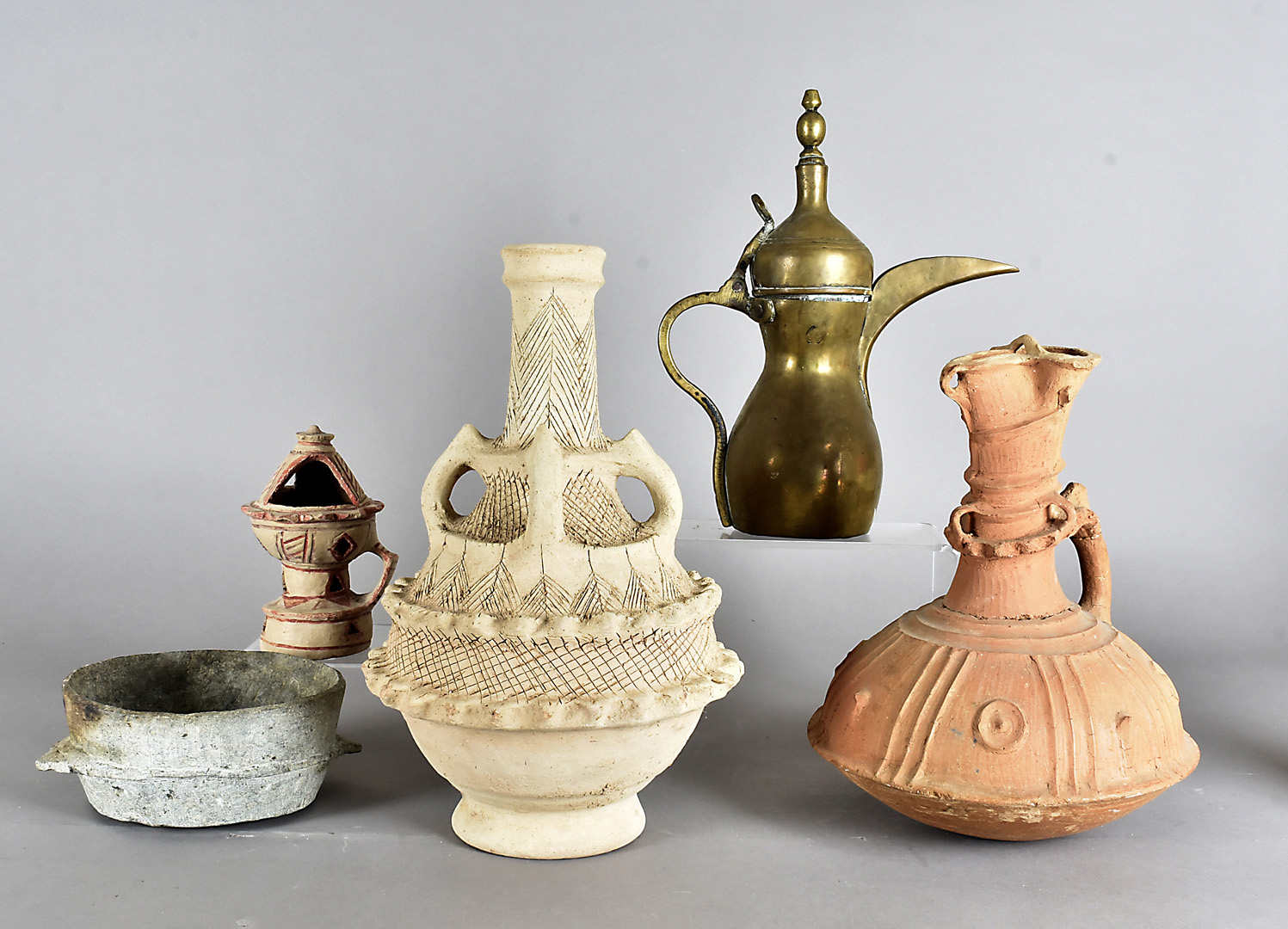 A large collection of various middle Eastern ceramics, including terracotta jugs, ancient oil