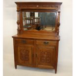 An oak British Art Nouveau mirror backed sideboard, having two carved panel doors below two frieze